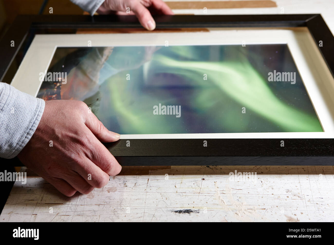 framer assembling complete picture frame in a framing workshop Stock Photo