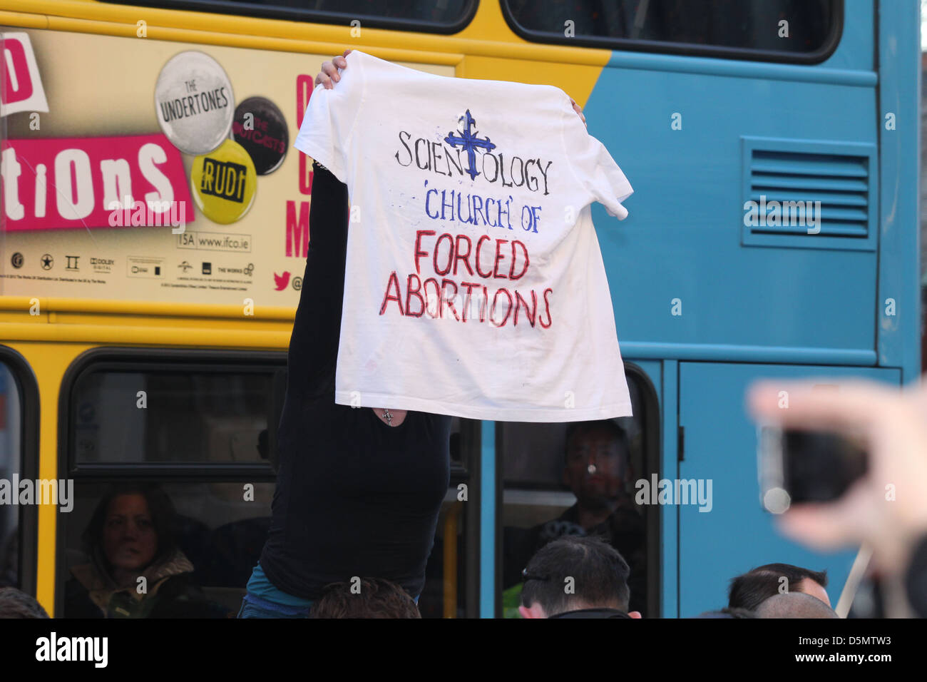 A woman holds an anti-Scientology t-shirt as group Anonymous protest  against Scientology at the European premiere of 'Oblivion' Stock Photo -  Alamy