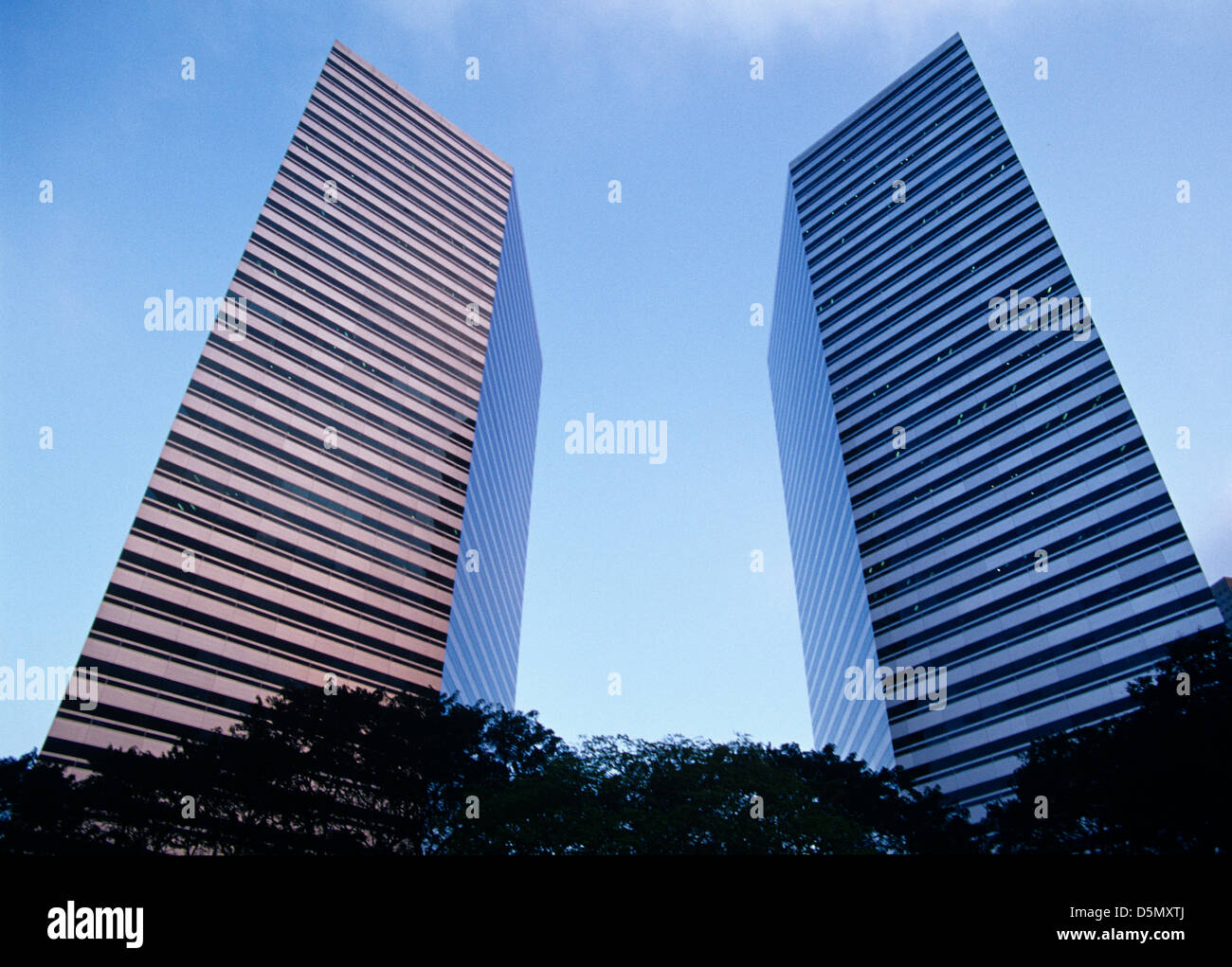 twin buildings rise above Raffles center in singapore Stock Photo