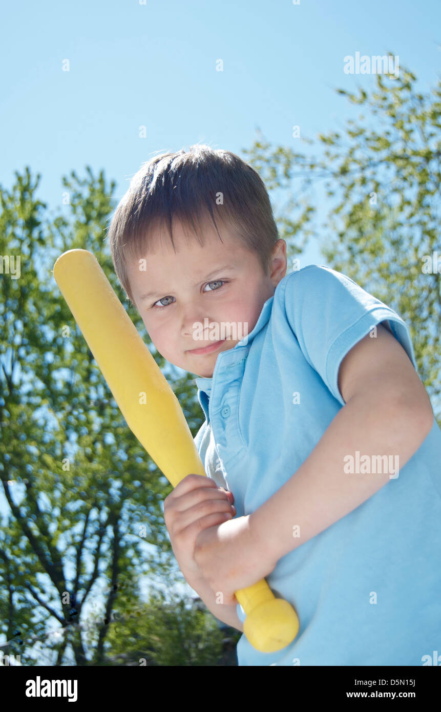 Little boy with yellow plastic bat in sunlight, Spring and baseball