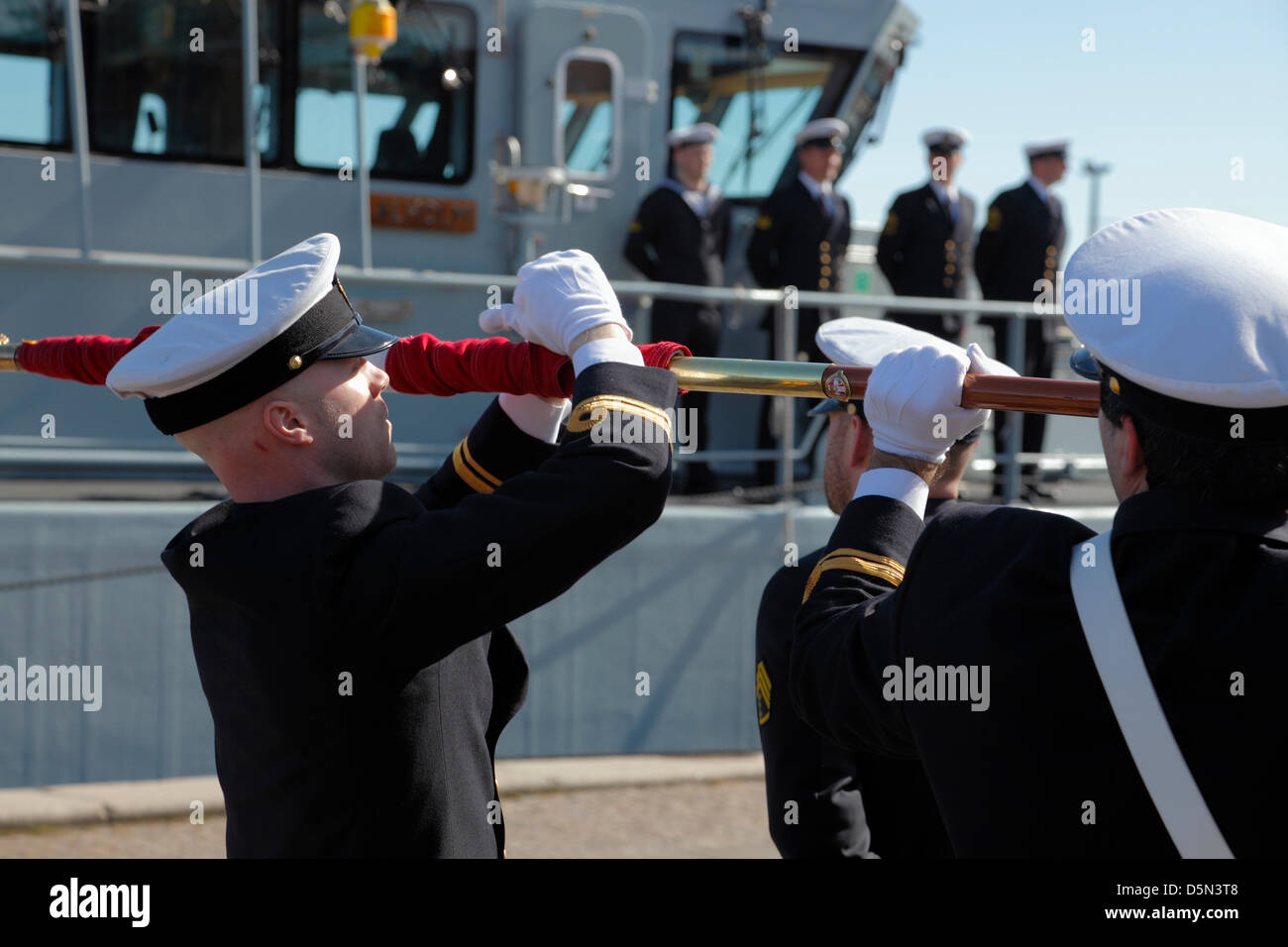 Copenhagen, Denmark. April 4th 2013. Cadets from the Royal Danish Naval Academy roll and tie knots on the swallow-tails of the naval flag after a parade through Copenhagen before the flag is paraded on board the naval training ship Alholm at Amaliehaven quay to mark the beginning of a new sailing season. Credit:  Niels Quist / Alamy Live News Stock Photo