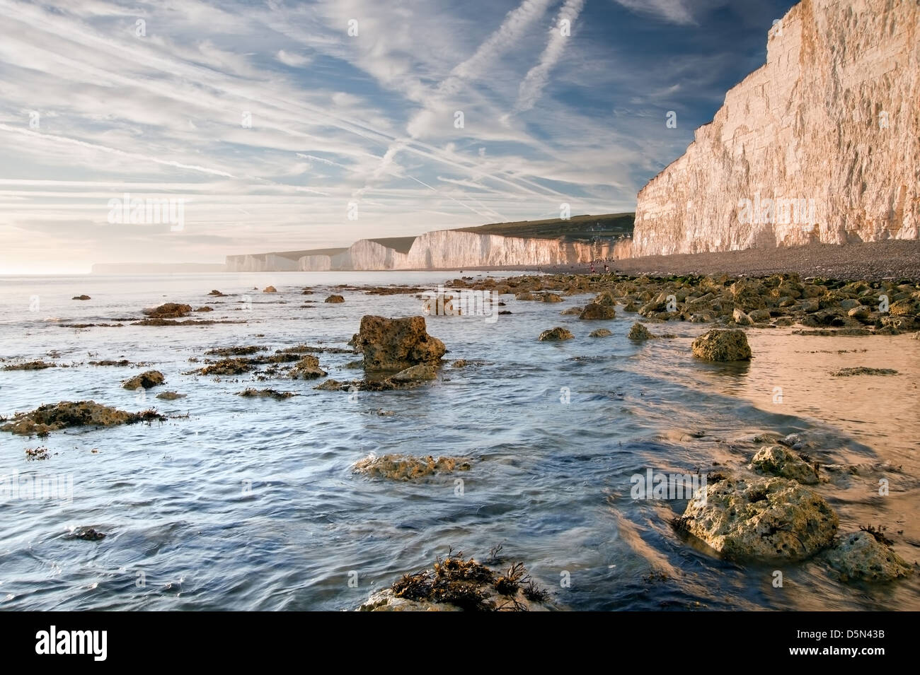 Stunning Summer sunset over ocean with cliffs, rocks and vibrant colors ...