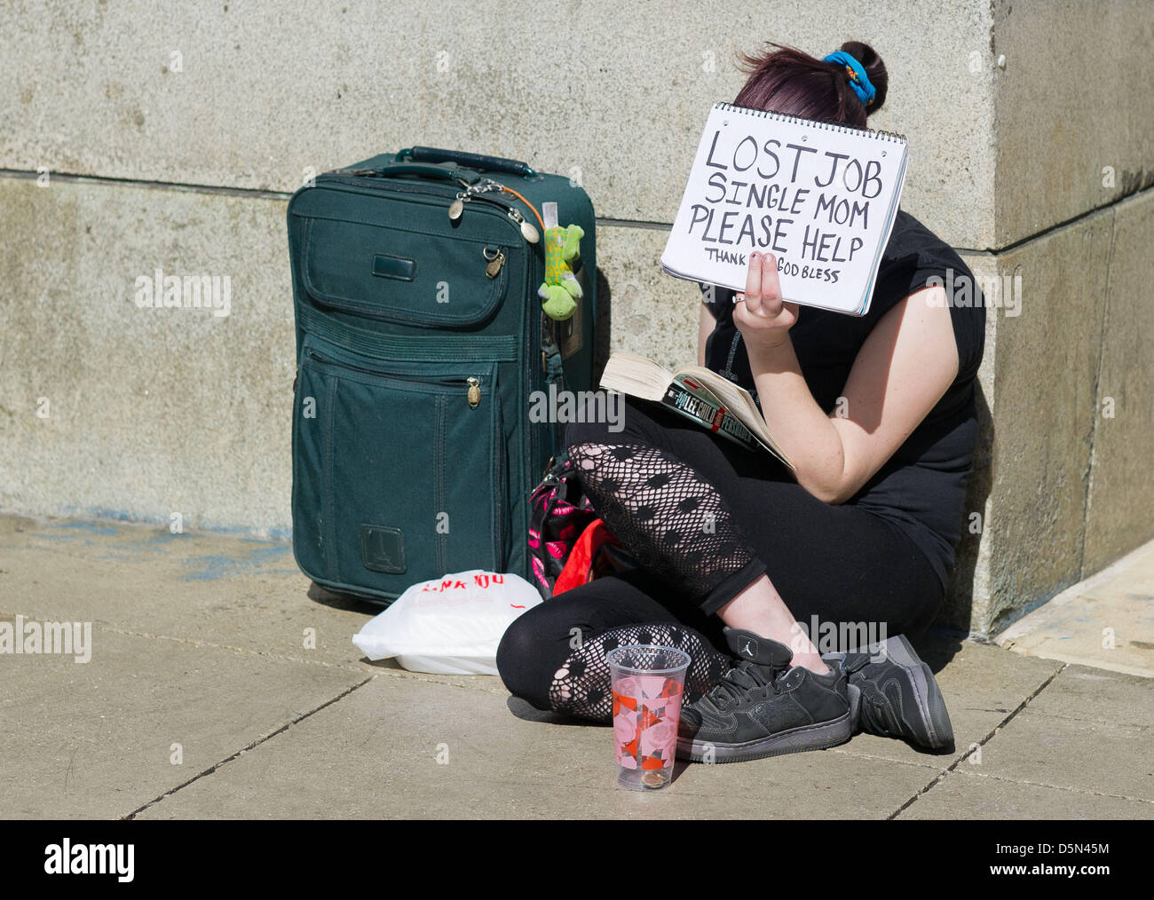 ARCHIV - A fire picture dated 22 May 2012 shows a woman holding a sign with the lettering 'Lost Job. Single Mom. Please Help' in her hand in Chicago, USA. Photo: Peer Grimm Stock Photo