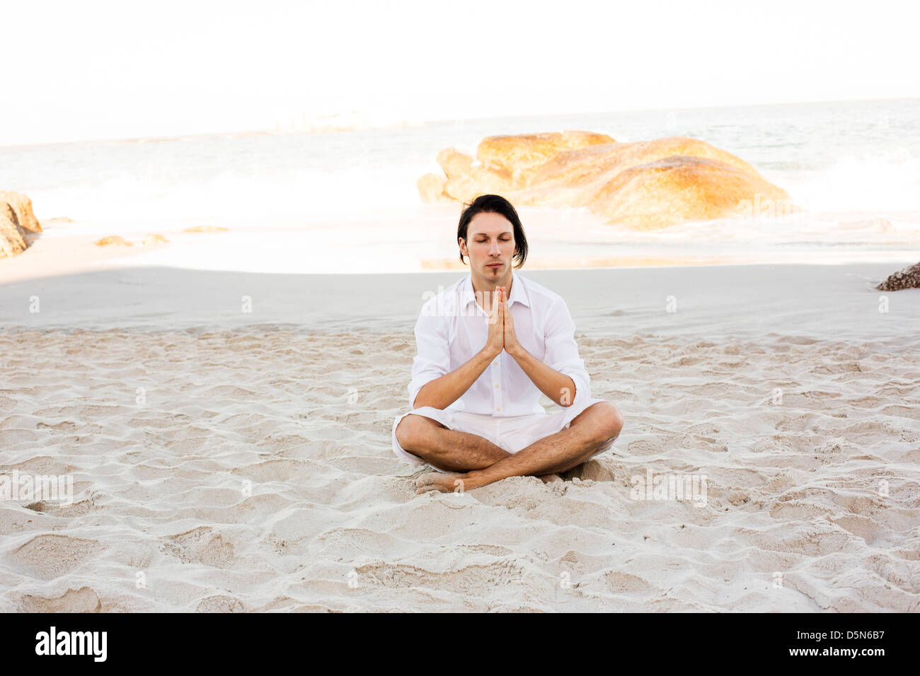 Man Meditating on Beach Stock Photo - Alamy