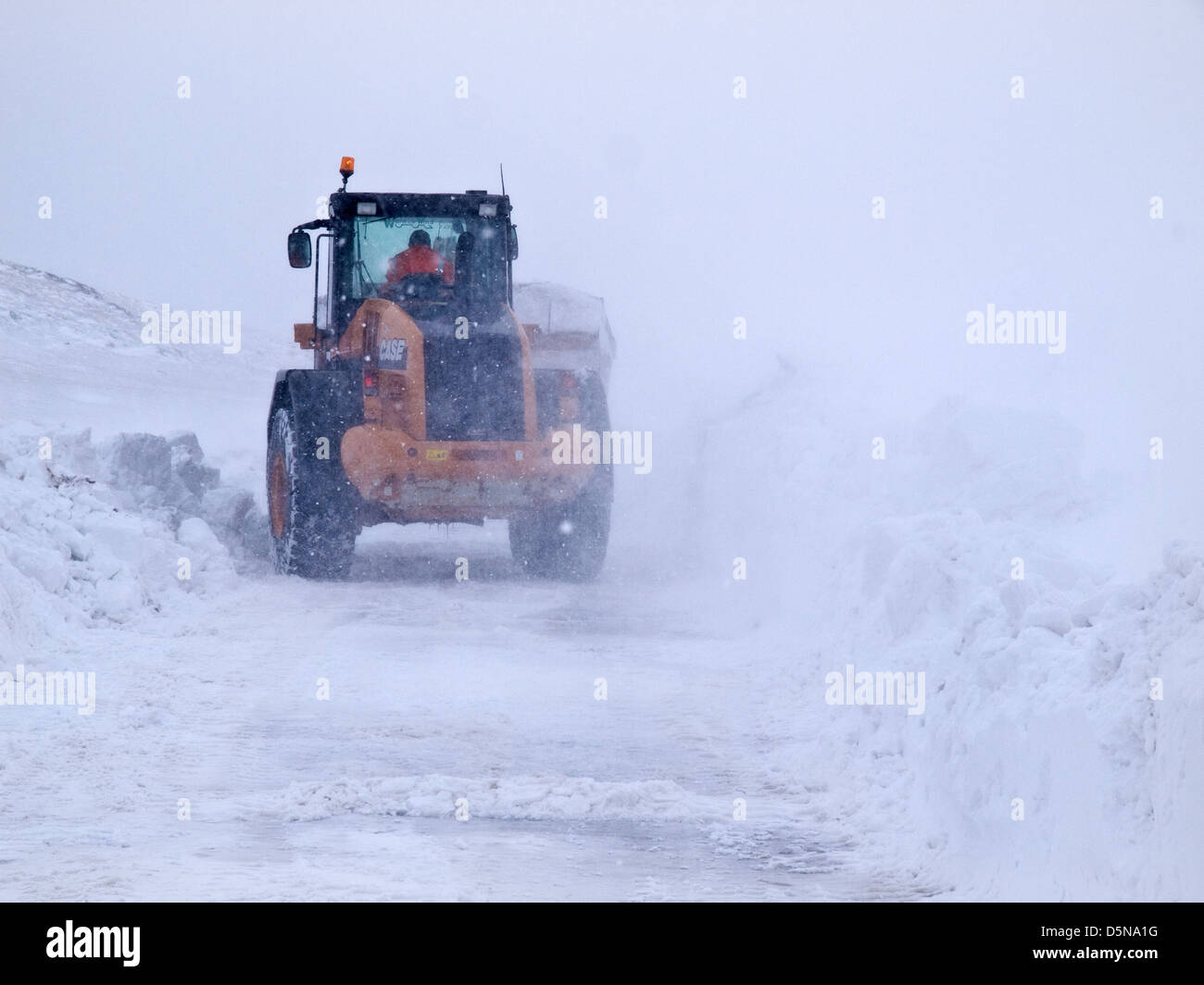 A tractor / digger trying to keep a Peak District road open in heavy ...