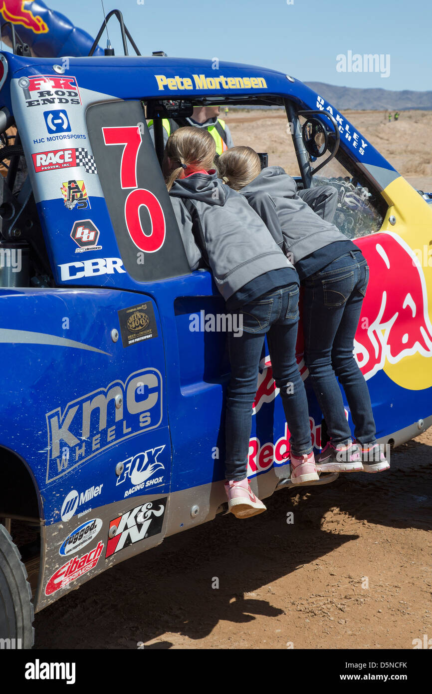 Two girls inspect the cab of a race car before the start of the Mint 400 off-road auto race through the Mojave Desert Stock Photo