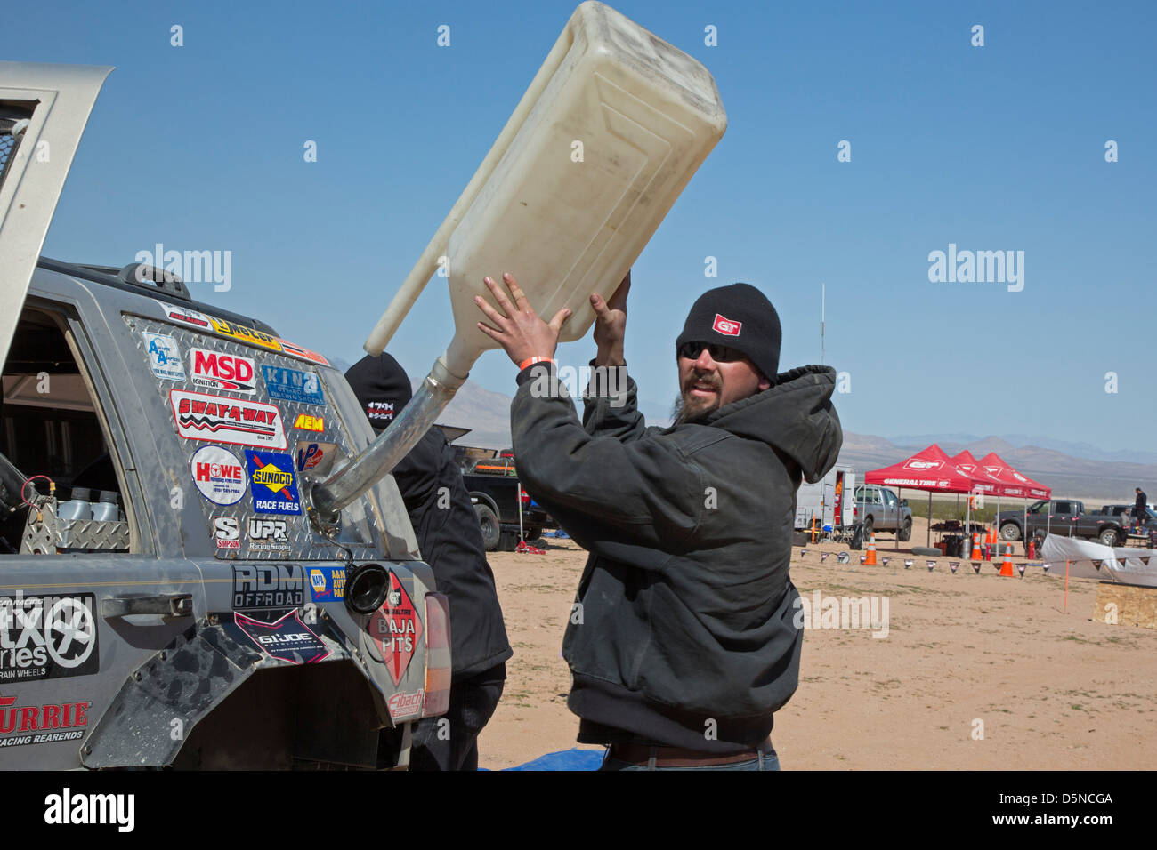 A crew members refuels a car in the pits during the Mint 400 off-road auto race through the Mojave Desert Stock Photo