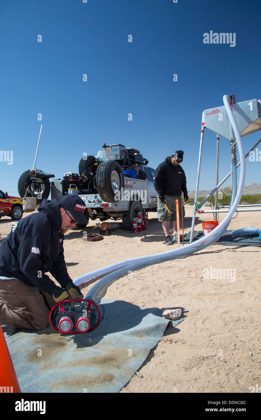 A crew member works on his team's refueling system in the pits during the Mint 400 off-road auto race through the Mojave Desert Stock Photo