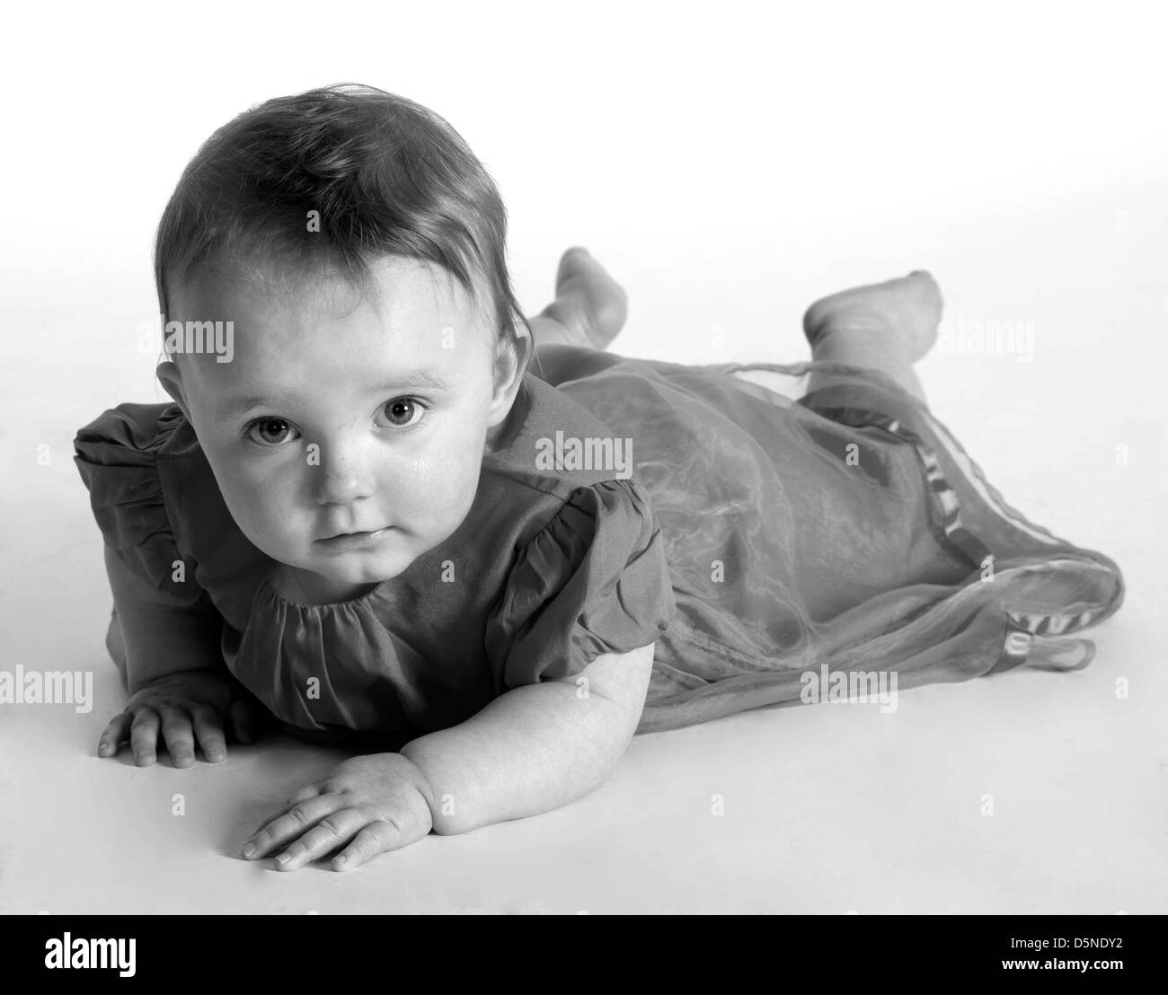 Black and white image of a baby lying on stomach in studio Stock Photo