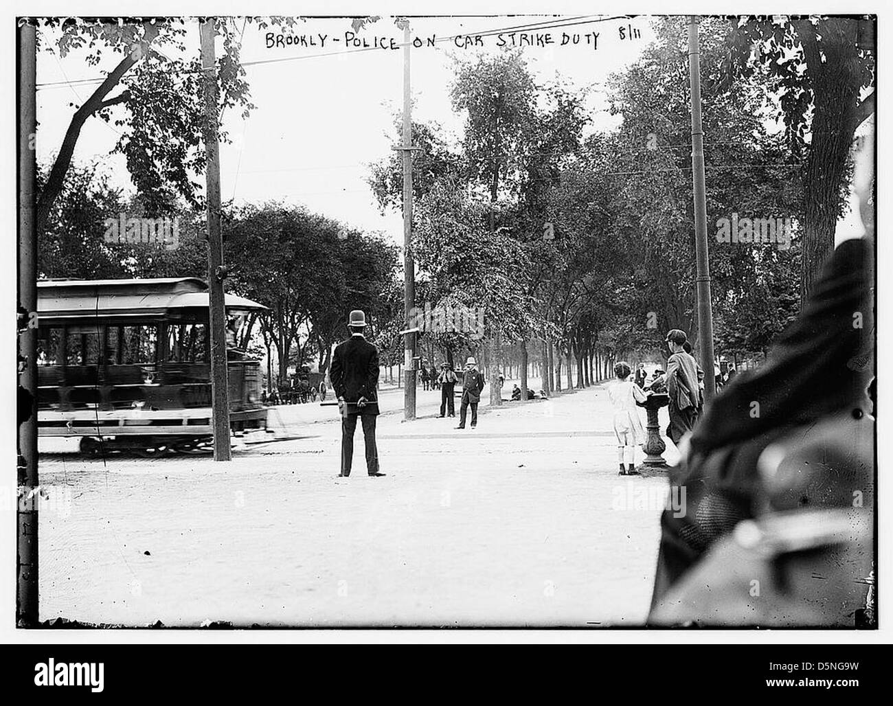 This photograph shows Brooklyn police officers on strike duty during a streetcar strike in New York City. The officers are seen guarding the area while the strike unfolds, reflecting labor unrest in the 1910s. Stock Photo