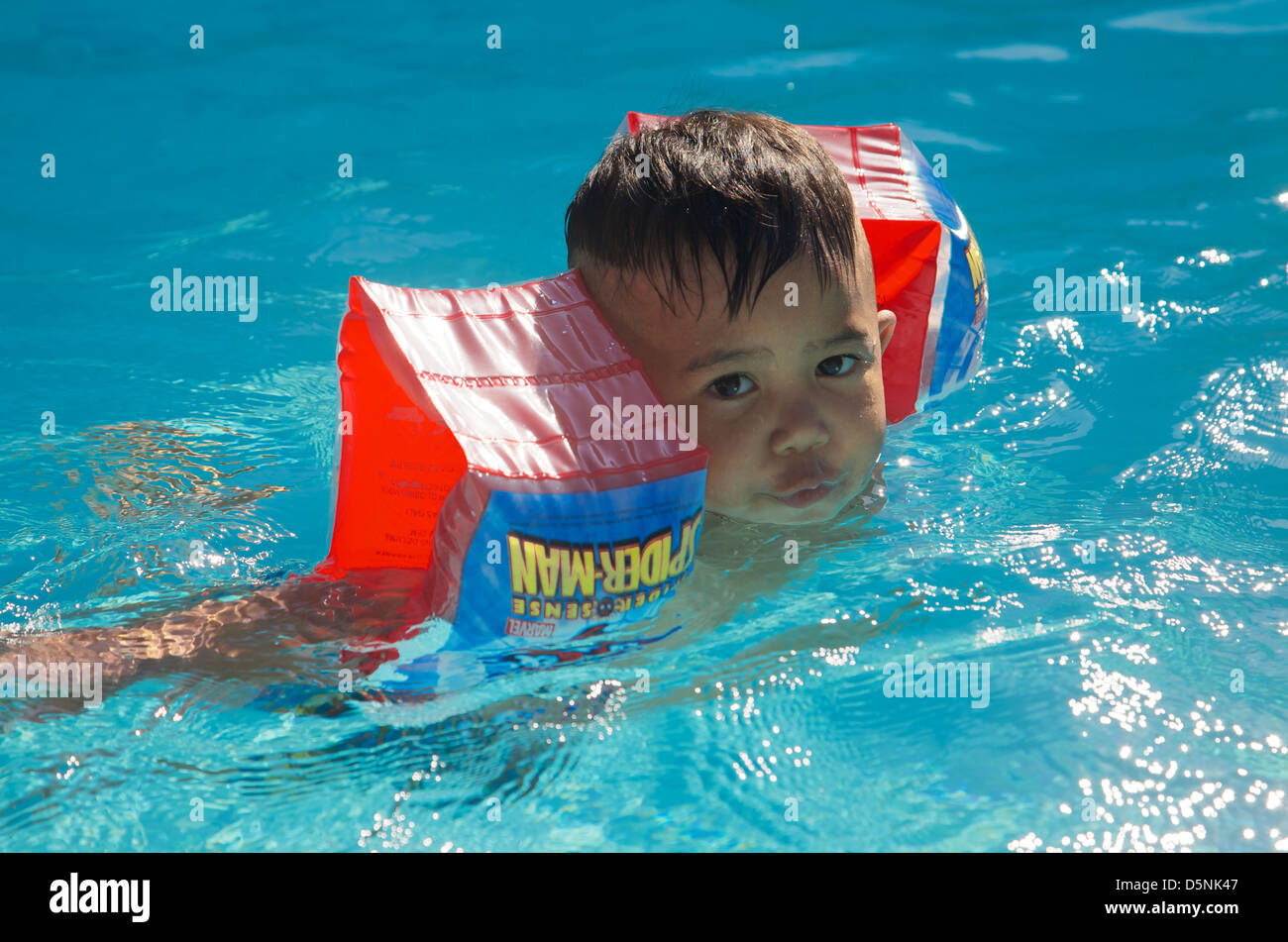 A 1 year old boy leaning to swim, Thailand Stock Photo