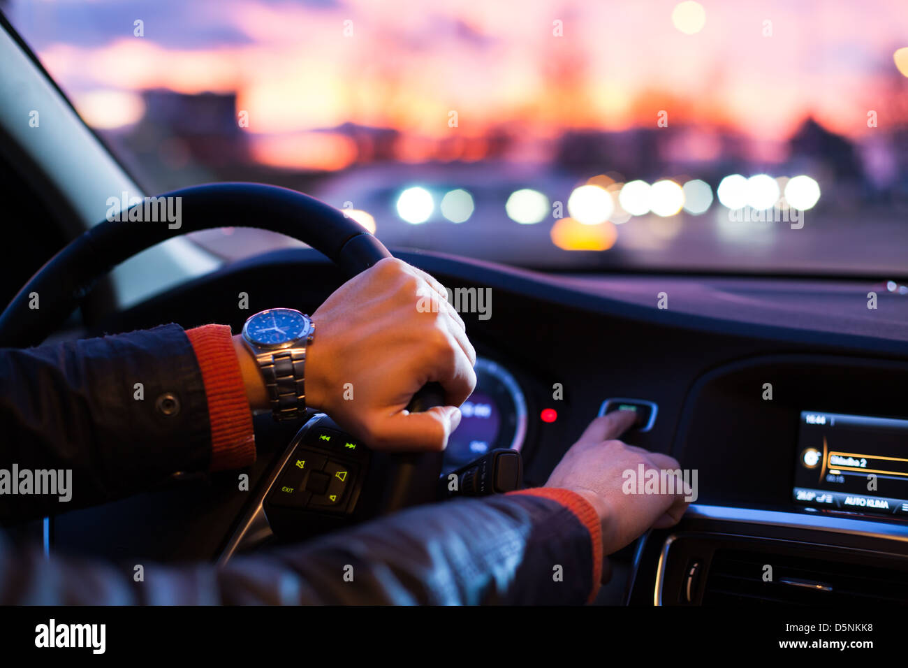 Driving a car at night -man driving his modern car at night in a city ...