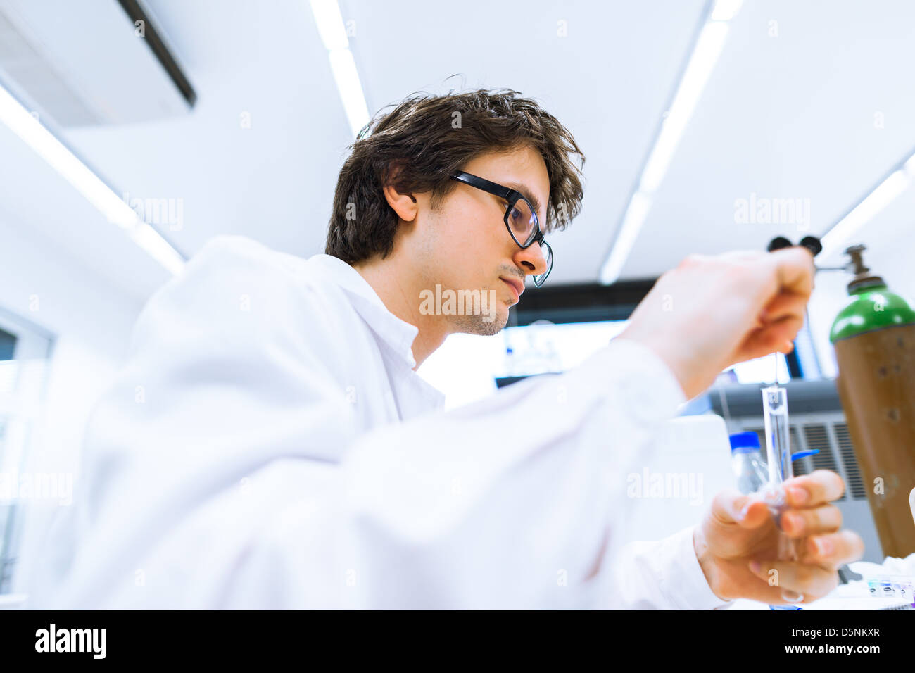 Assistant scientist. Мужчина в лаборатории. Парень в лаборатории. Парень исследователь. Стоковые картинки парень ученый измеряет.
