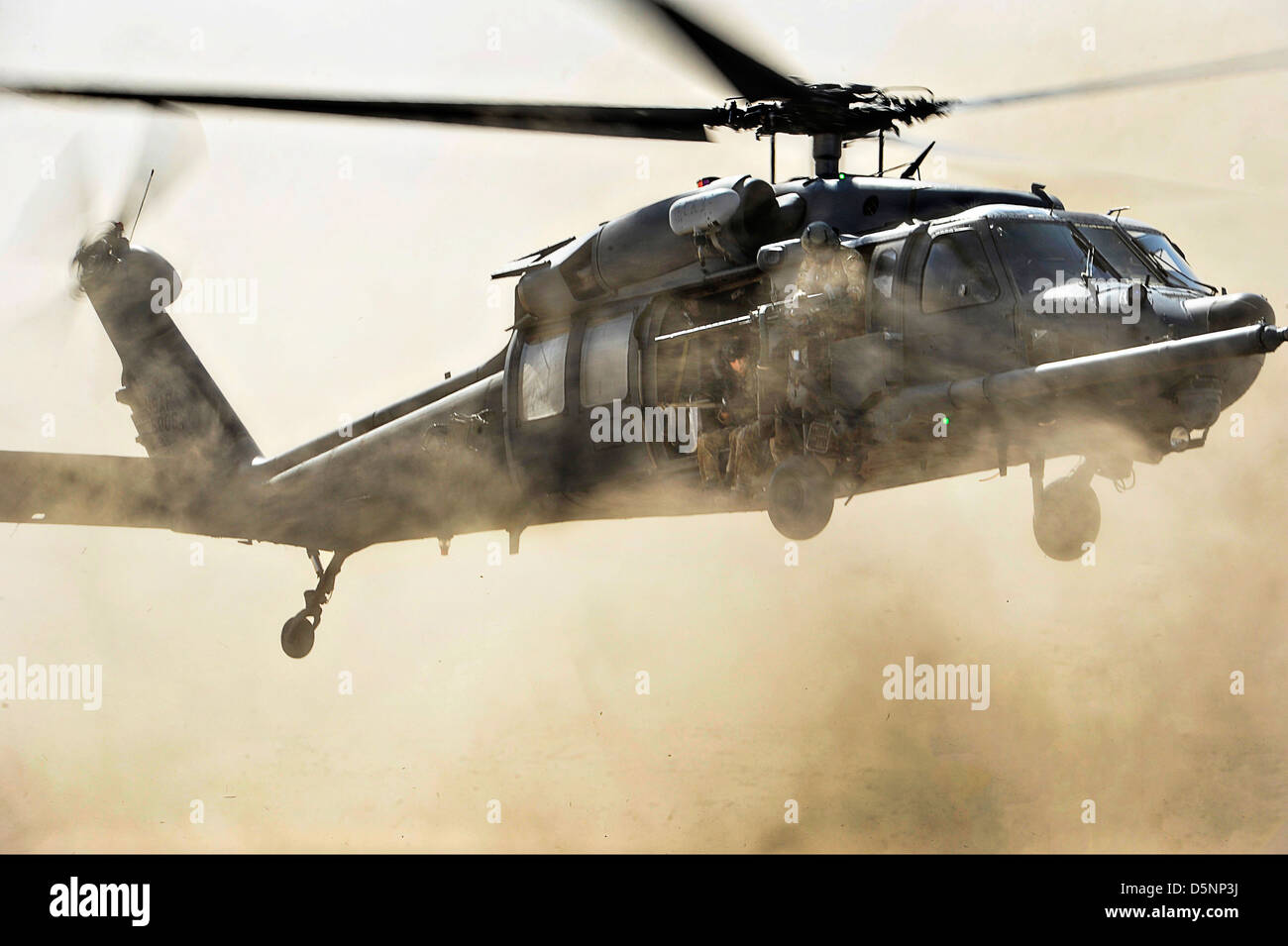 A US Air Force HH-60G Pave Hawk helicopter comes in for a fast landing to pick up pararescuemen during a combat search and rescue exercise March 23, 2013 in the Grand Bara Desert, Djibouti. Stock Photo