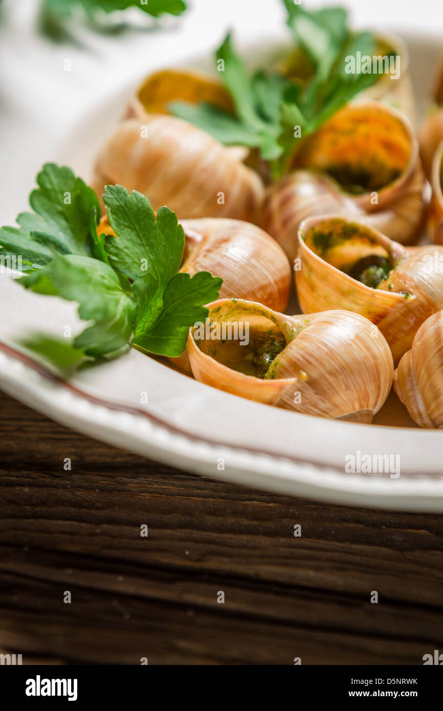 Closeup of baked snails with parsleyand garlic butter Stock Photo - Alamy