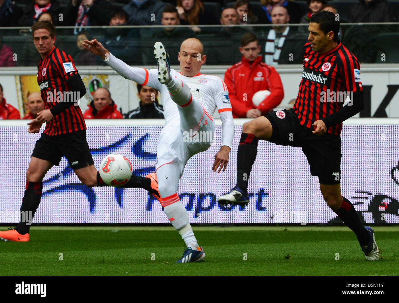 Frankfurt's Karim Matmour (R) and Bastian Oczipka vie for the ball with Munich's Arjen Robben (C) during the Bundesliga soccer between Eintracht Frankfurt and Bayern Munich at Commerzbank Arena in Frankfurt Main, Germany, 06 April 2013. Photo: ARNE DEDERT  (ATTENTION: EMBARGO CONDITIONS! The DFL permits the further  utilisation of up to 15 pictures only (no sequntial pictures or video-similar series of pictures allowed) via the internet and online media during the match (including halftime), taken from inside the stadium and/or prior to the start of the match. The DFL permits the unrestricted  Stock Photo