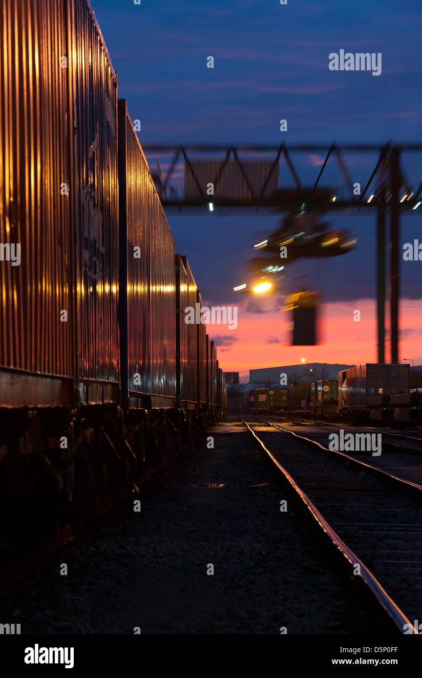 Beautiful view of cranes working at Manchester Freightliner railway freight terminal at dusk. Stock Photo