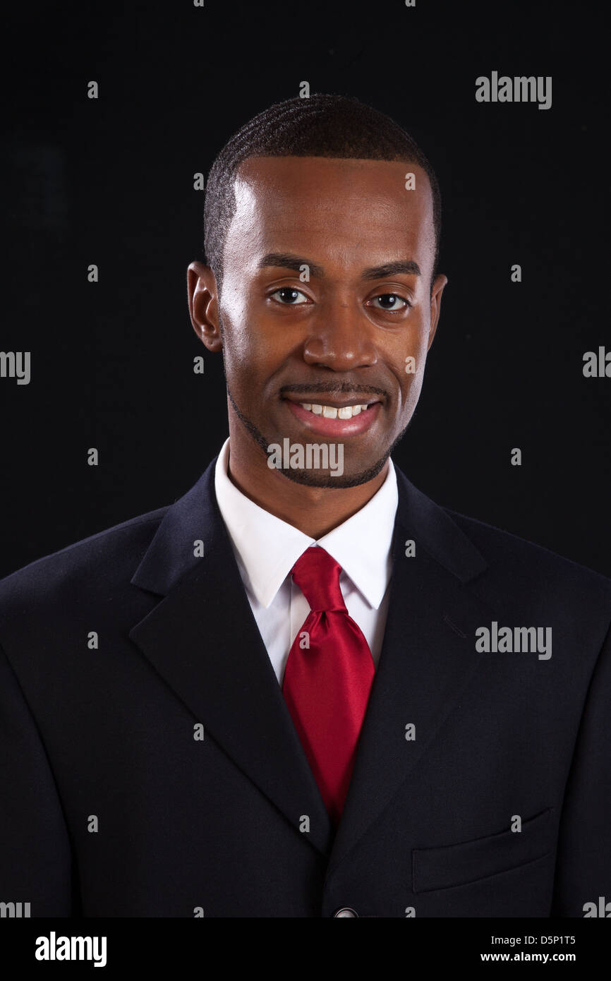 Black man in dark suit, white shirt and red tie, a successful ...