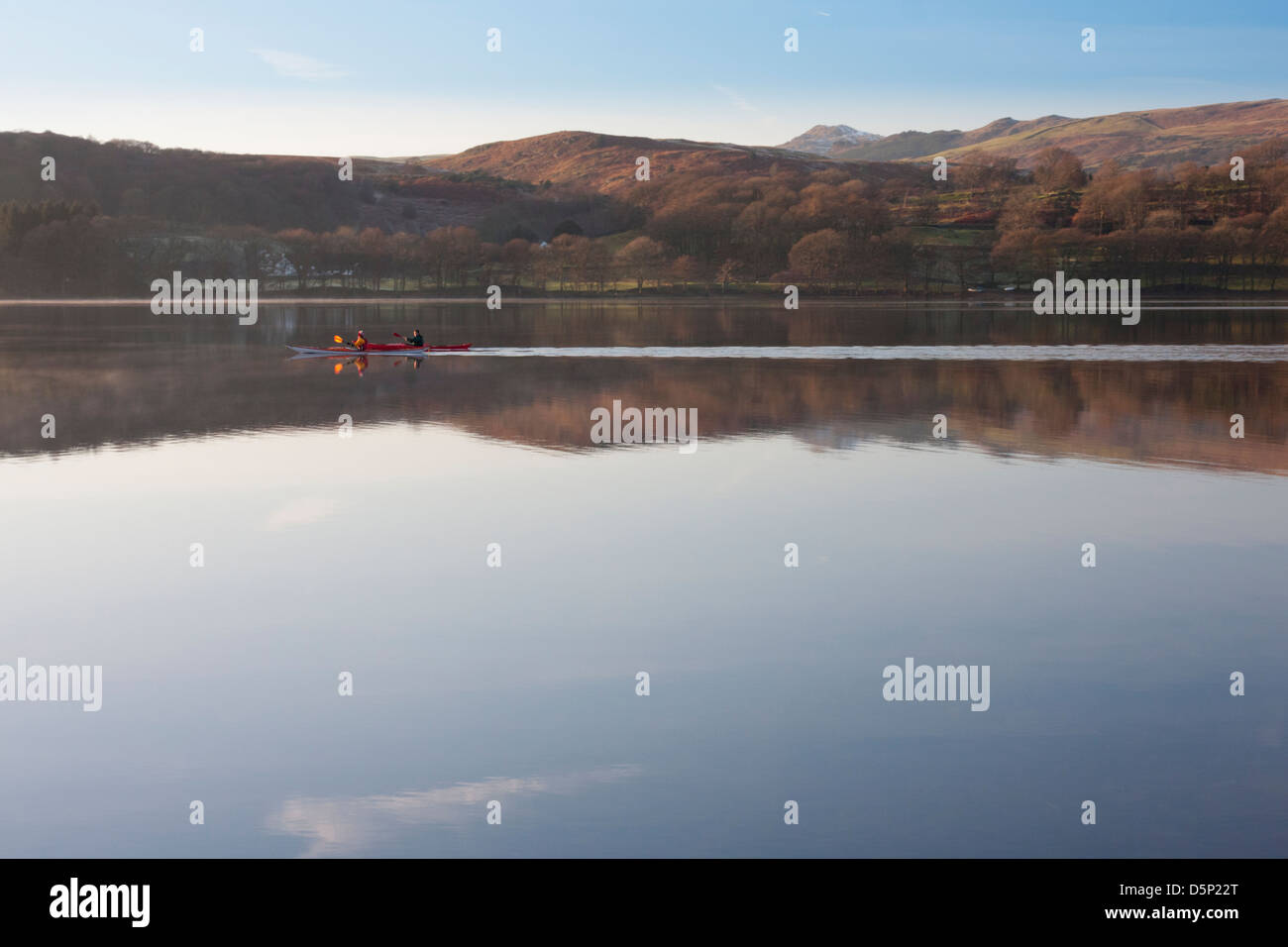 Two men in a Canadian kayak paddle across a very still Coniston water ...