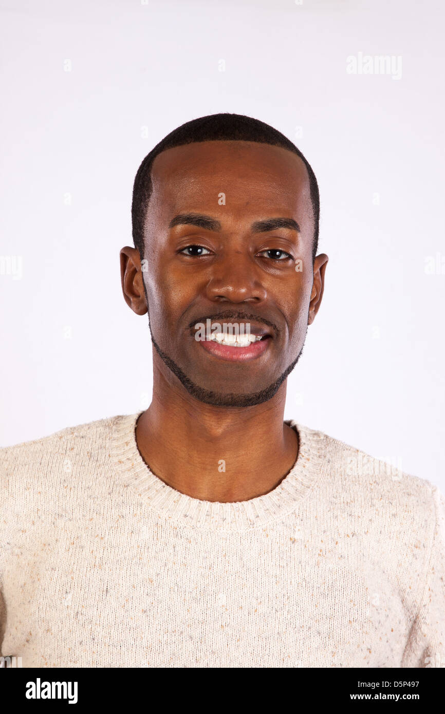 Handsome black man wearing a white pull over sweater,  looking at the camera with a happy smile Stock Photo
