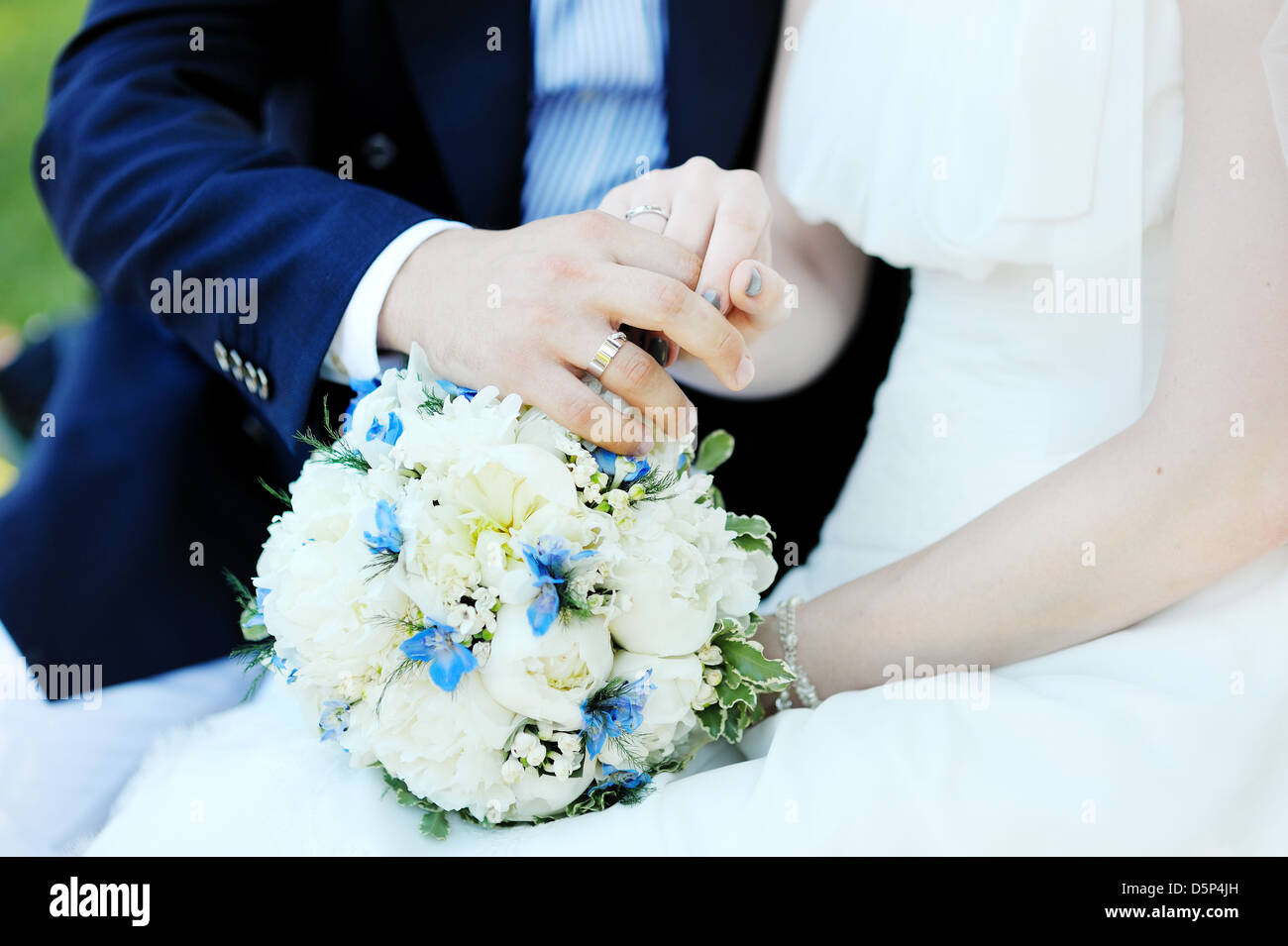 hands of the bride and the groom with bouquet and wedding rings Stock ...