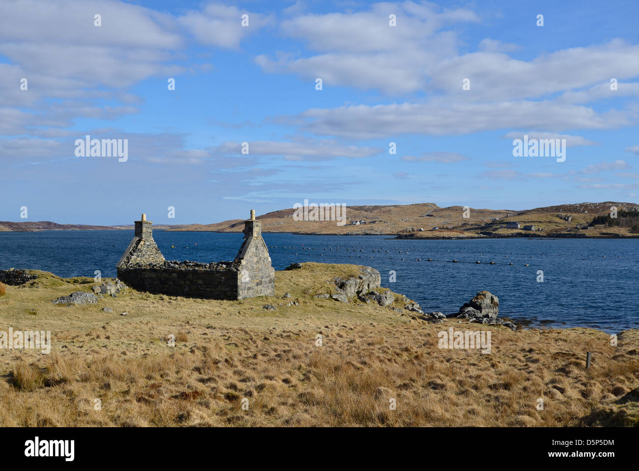 A ruined old croft house sits on the shore overlooking Loch Barraglom between the Isle of Lewis and Great Bernera. Stock Photo