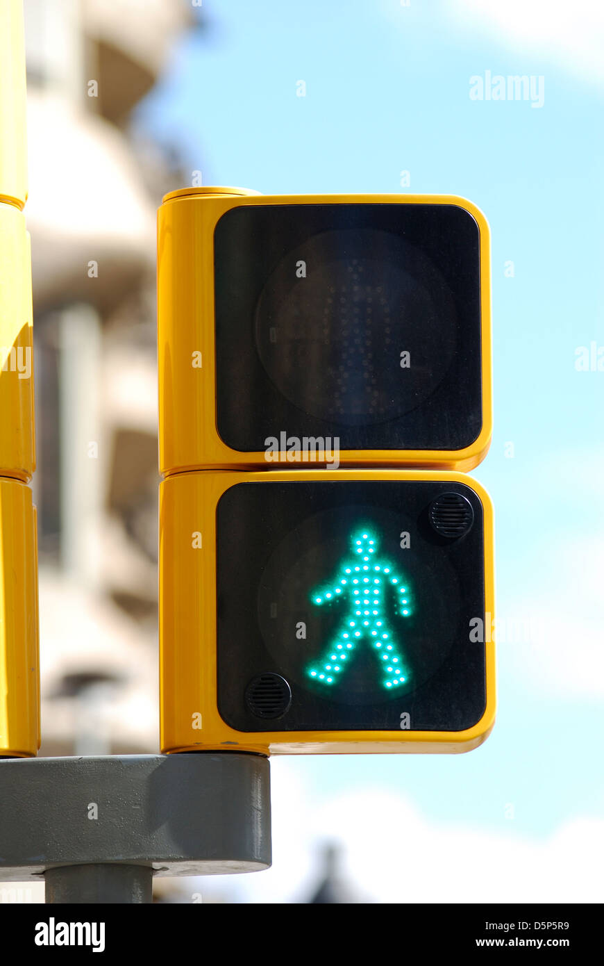 Pedestrian signal light showing green walking man in city centre of