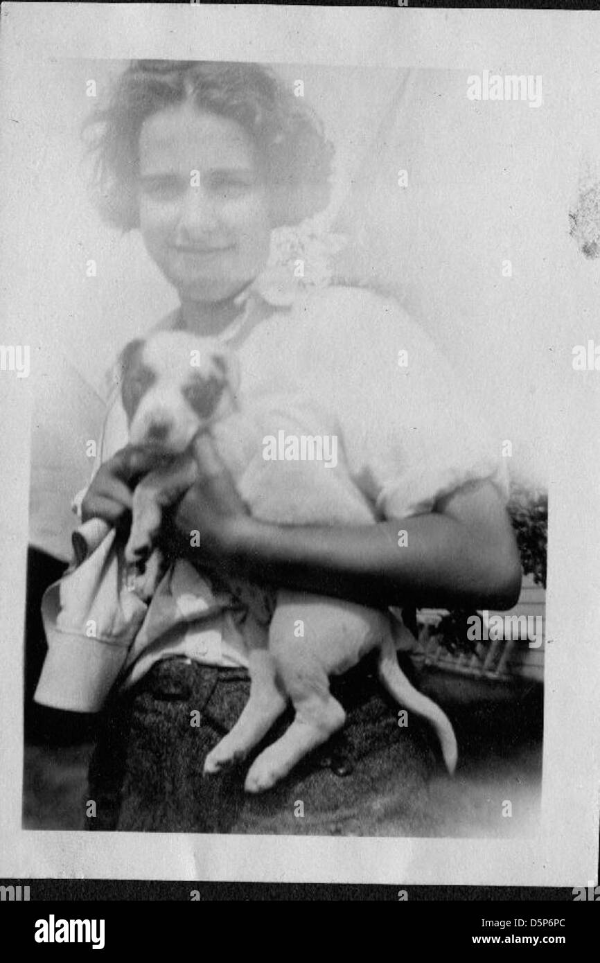 Helen Richey, a young woman aviator, is captured smiling with a puppy ...