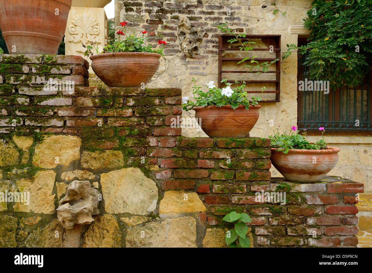Terracotta flowerpots on an outdoor staircase wall in rustic hillside town of Yesilyurt Malatya Turkey Stock Photo