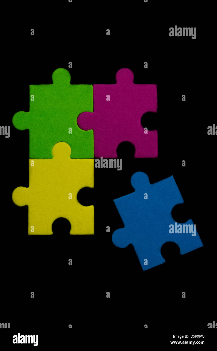 Colorful puzzle pieces over black background representing variety and tolerance Stock Photo