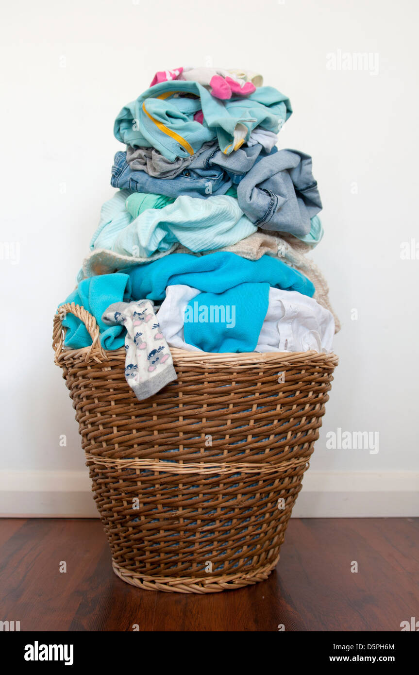 Wicker laundry basket overfilled with washing Stock Photo Alamy