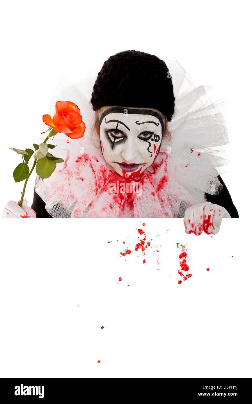 a fearsome female Clown with Rose looks over an edge Stock Photo