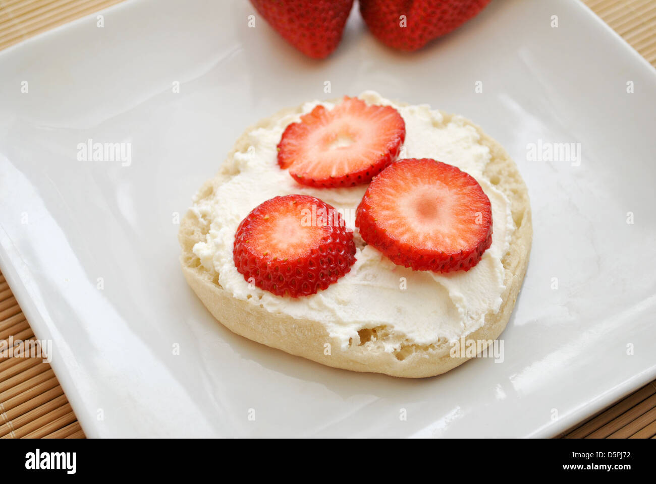 Sliced Strawberries with Cream Cheese on an English Muffin Stock Photo
