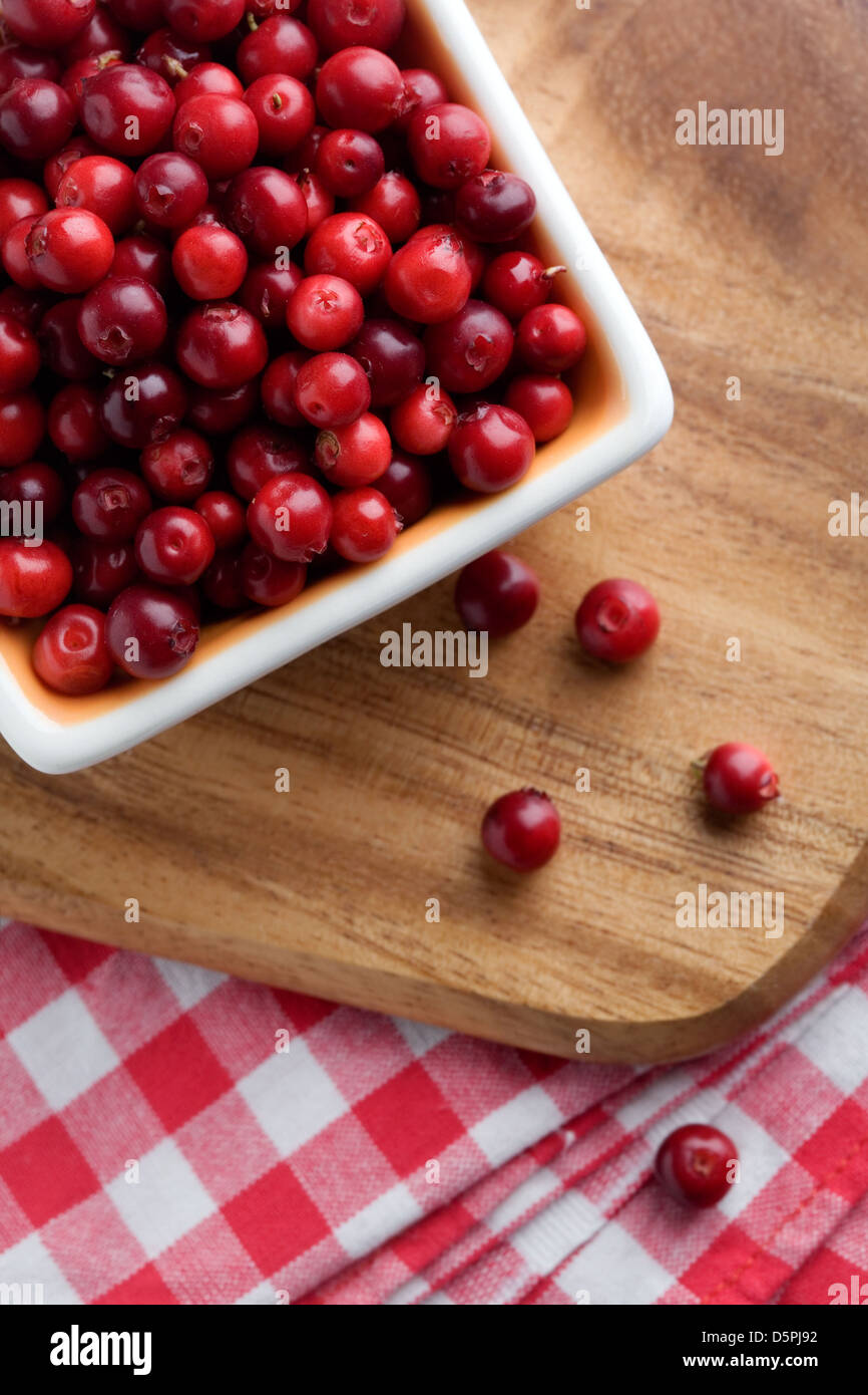 Fresh cranberries in white bowl, selective focus Stock Photo