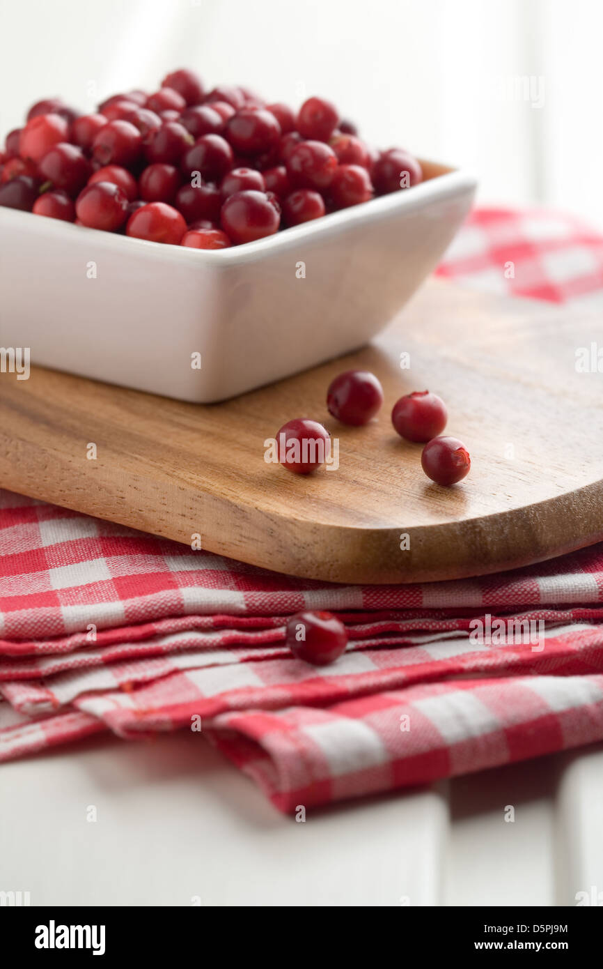 Fresh cranberries in white bowl, selective focus Stock Photo
