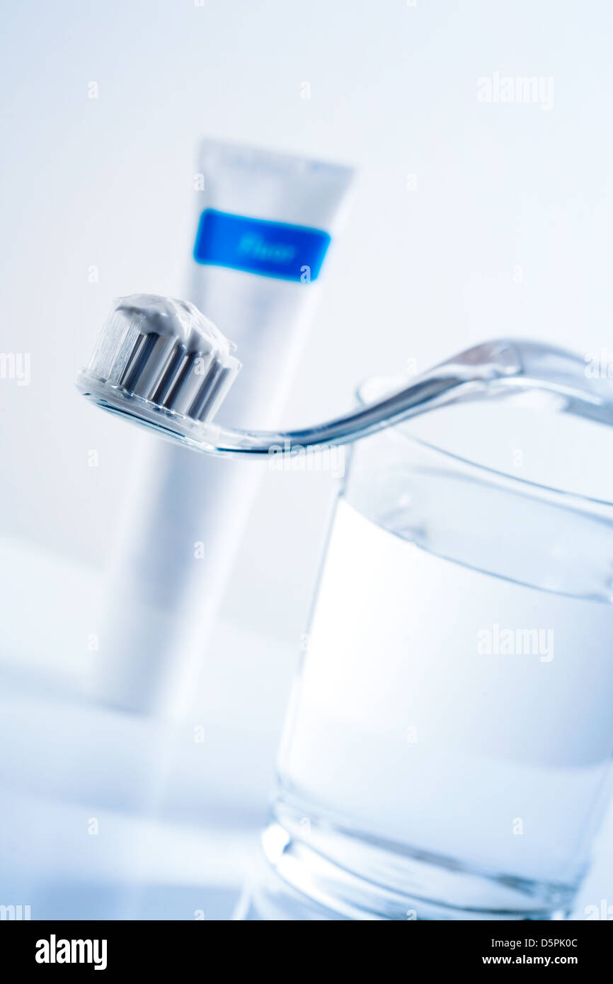 Toothbrush, toothpaste and glass of water on table Stock Photo Alamy
