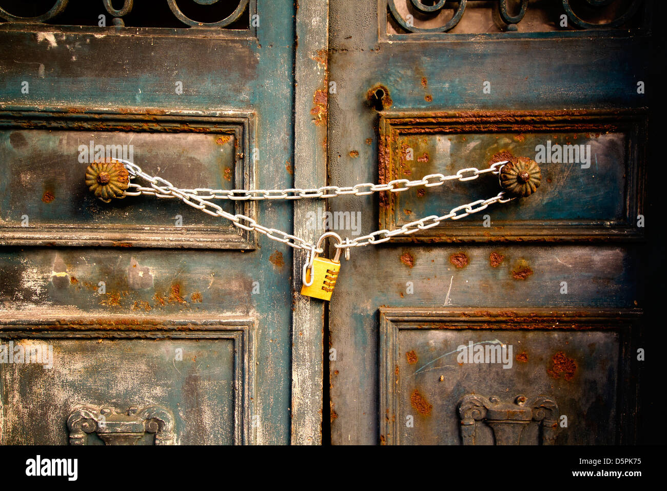 An old rusty iron door locked by steel chains Stock Photo