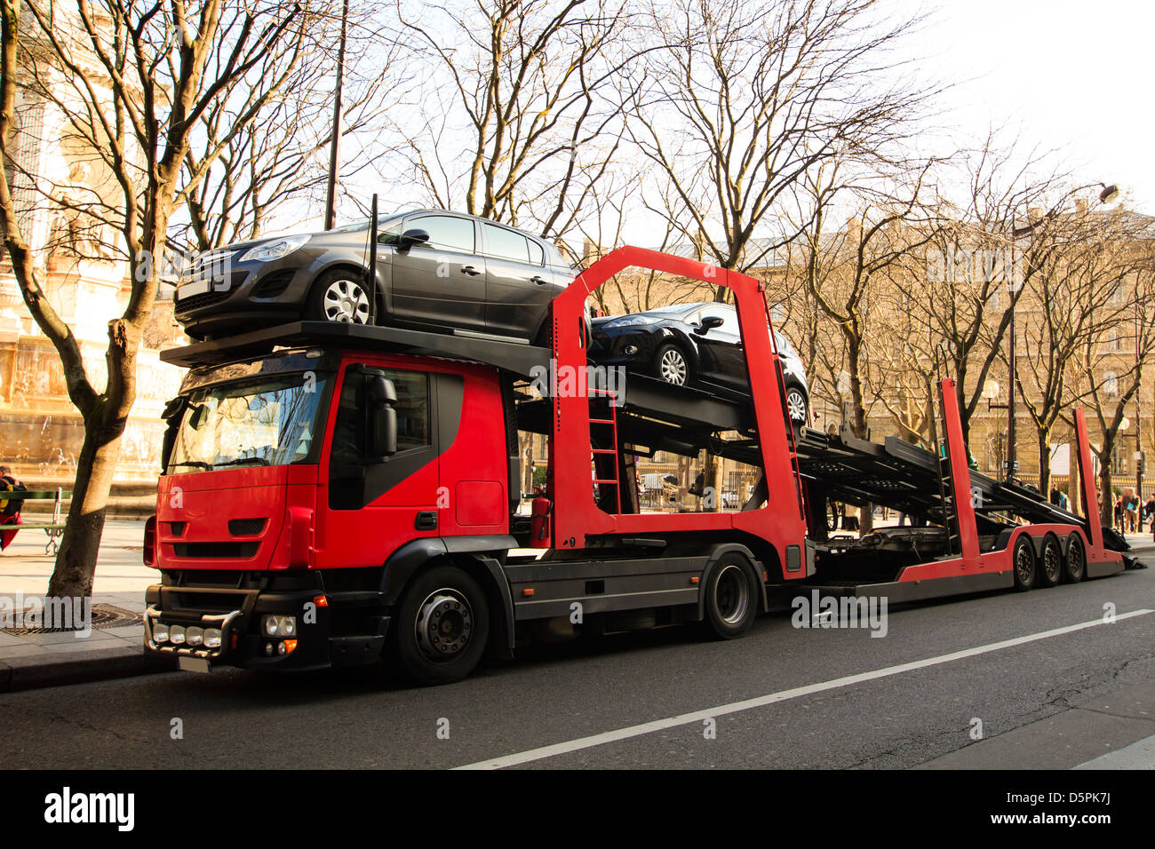 Red car carrier truck with two cars loaded Stock Photo