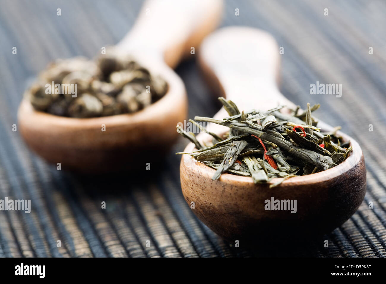Fresh green tea leaves on wooden spun Stock Photo