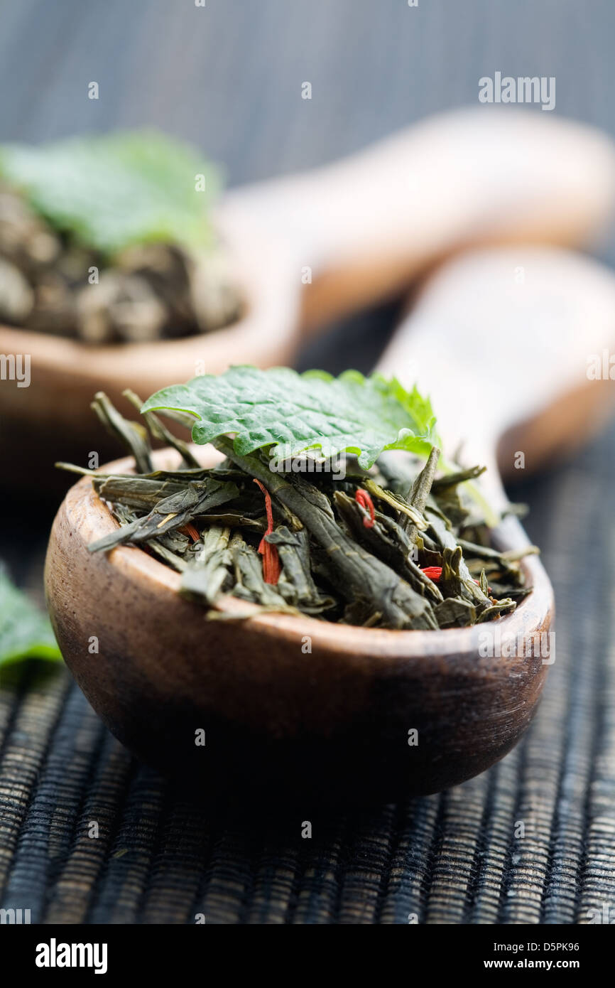 Fresh green tea leaves on wooden spun Stock Photo