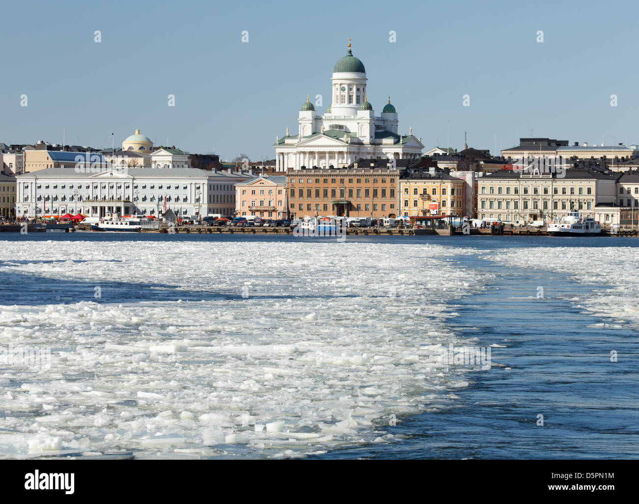 April sun is setting South Harbor of Helsinki free from ice, shining at facades and the domes of the Lutheran Cathedral. Stock Photo