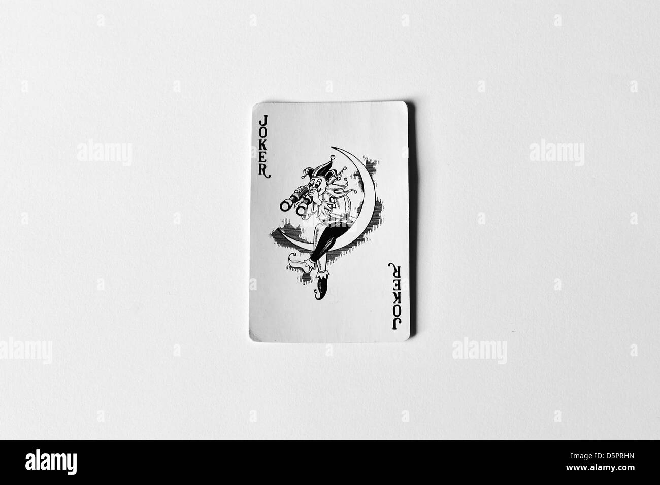 A Joker playing card photographed in a studio against a white background. Stock Photo