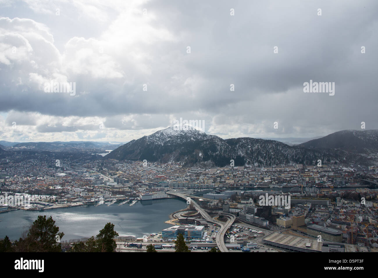 April sun over Bergen City centre south part during undtable weather as a snow cloud emerges from the North Sea. Stock Photo