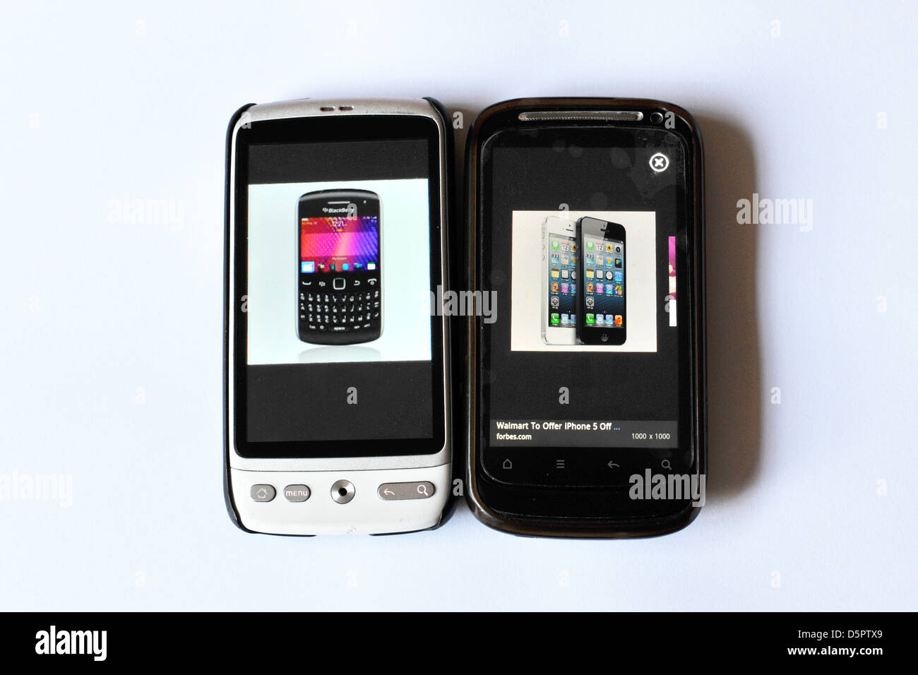 Two mobile phone screens showing Blackberry and iPhone web pages photographed in a studio. Stock Photo
