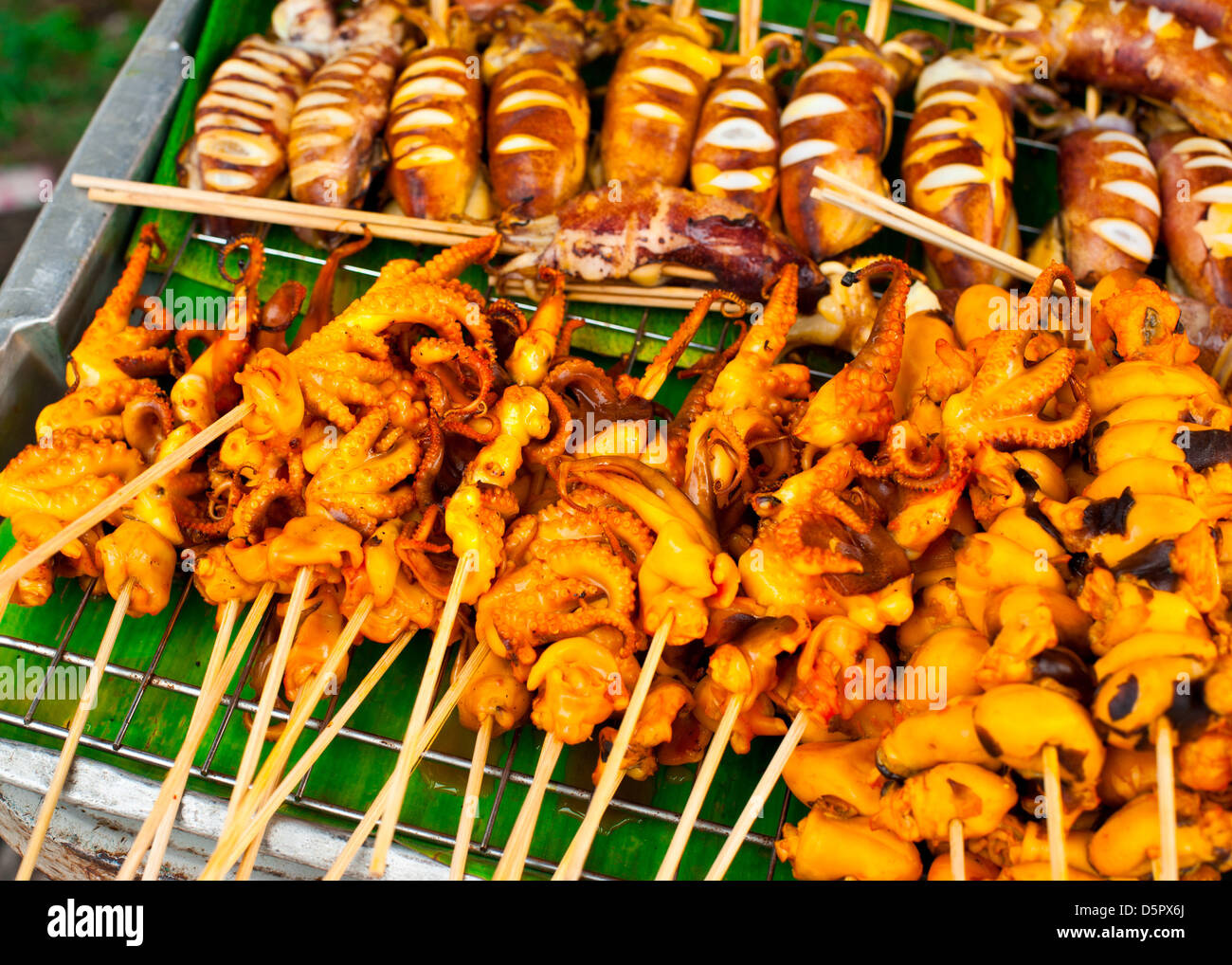 Traditional Thai food at market. Grilled seafood on sticks. Calamari, octopus and cuttlefish Stock Photo