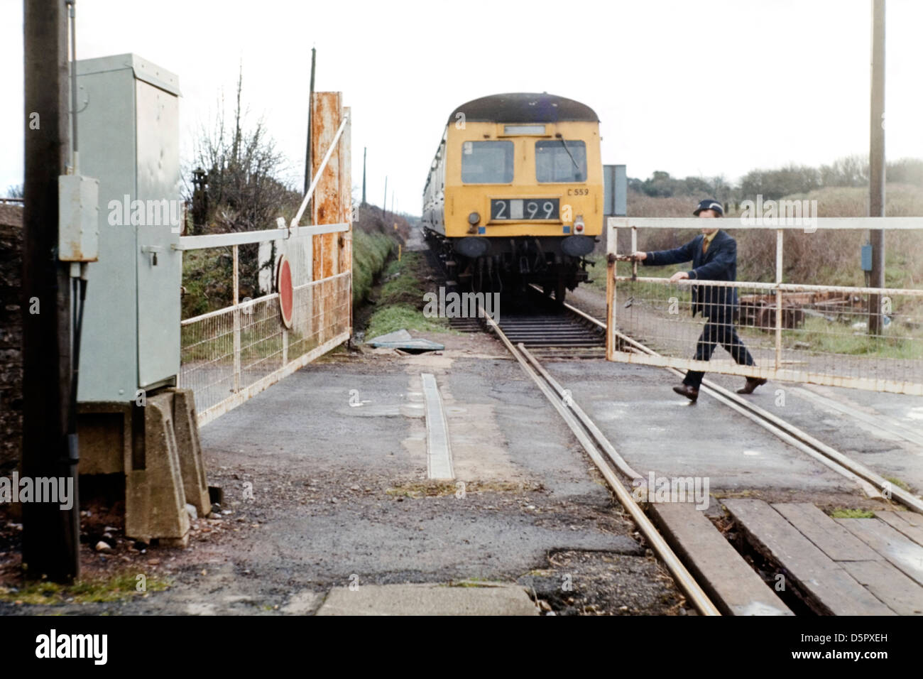 railway train guard manually closing a level crossing gates manorbier