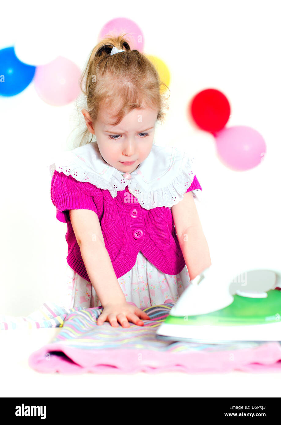 Cute little girl don't want to iron the clothes Stock Photo