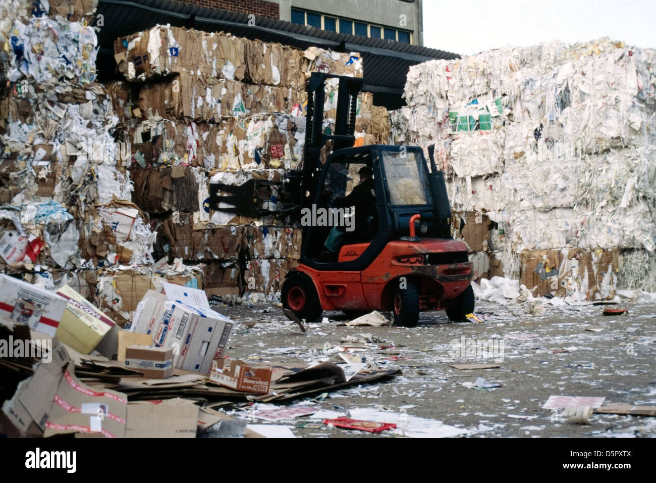 man in fork lift moving bales of waste paper at a recycling plant Stock Photo Alamy