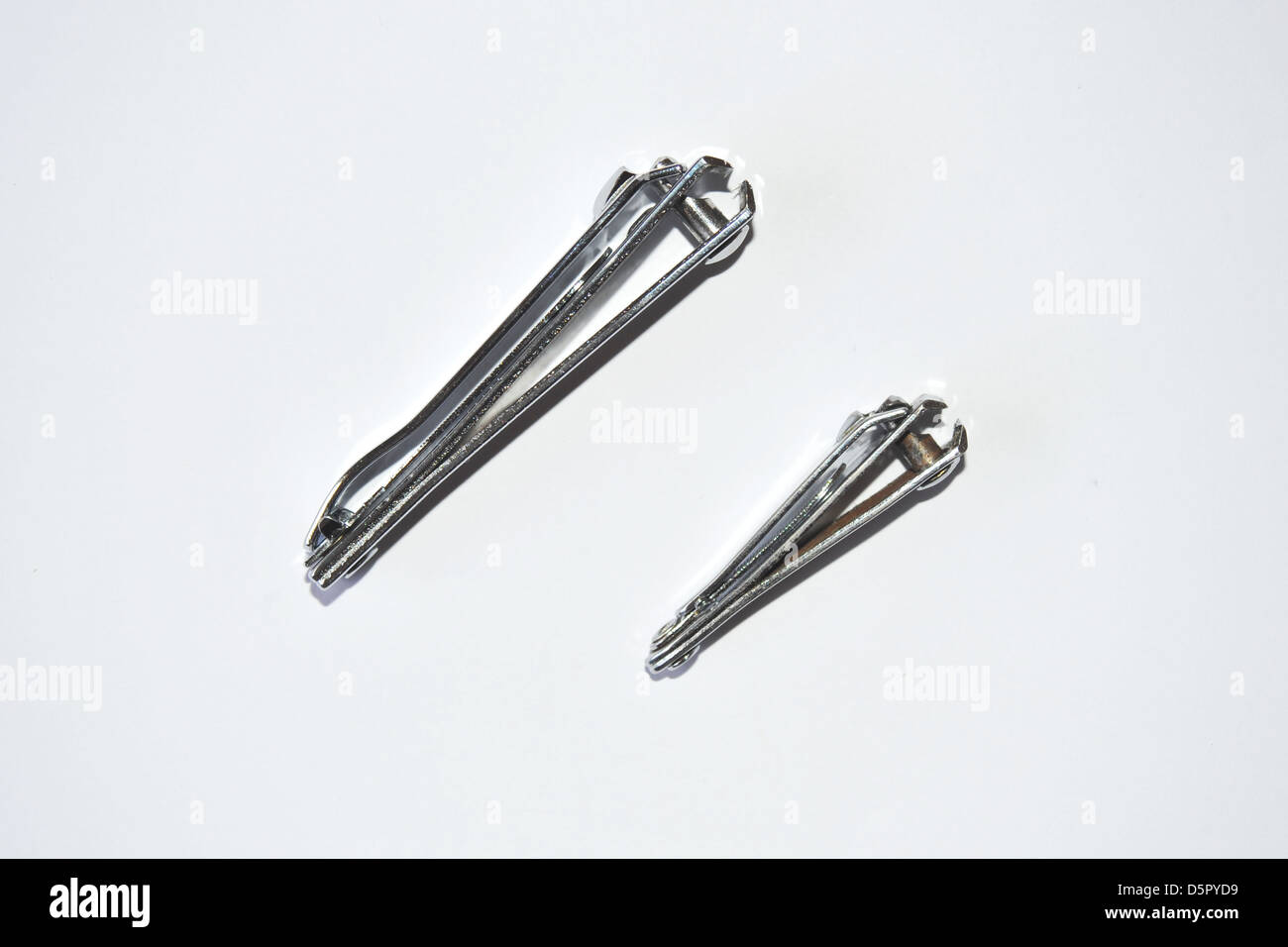 Two different sized nail clippers photographed in a studio. Stock Photo