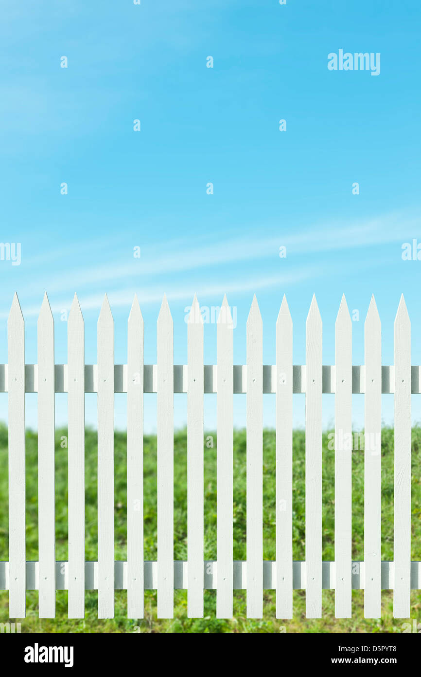 Newly painted white picket fence on a sunny day Stock Photo